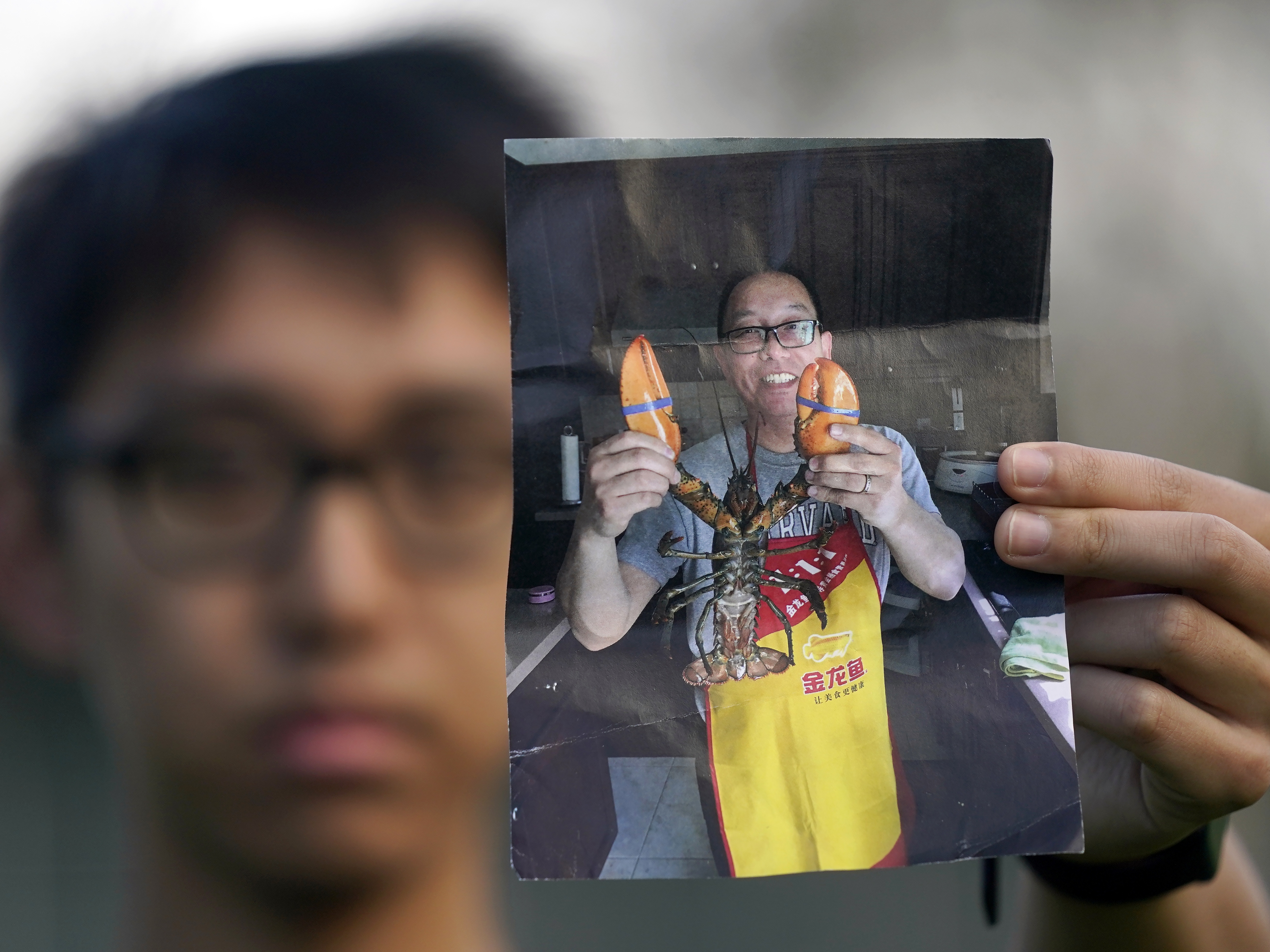 caption: Harrison Li holds a photo of his father, Kai Li, on Jan. 23, 2024, in Palo Alto, California.