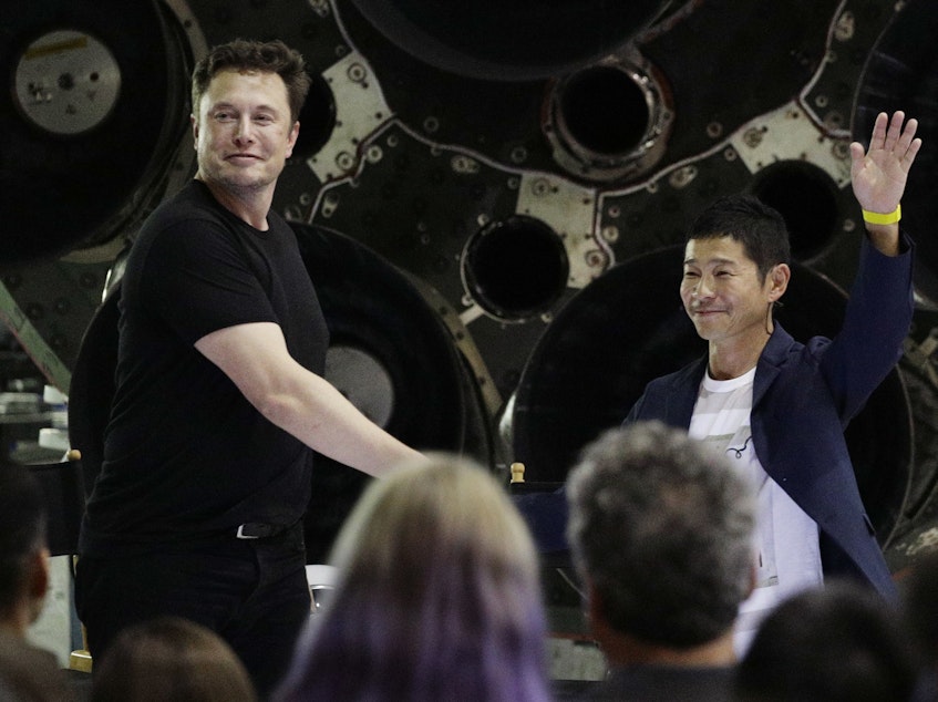 caption: SpaceX founder and chief executive Elon Musk, left, shakes hands with Japanese billionaire Yusaku Maezawa, right, on Monday, after announcing that he will be the first private passenger on a trip around the moon.