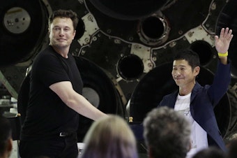 caption: SpaceX founder and chief executive Elon Musk, left, shakes hands with Japanese billionaire Yusaku Maezawa, right, on Monday, after announcing that he will be the first private passenger on a trip around the moon.