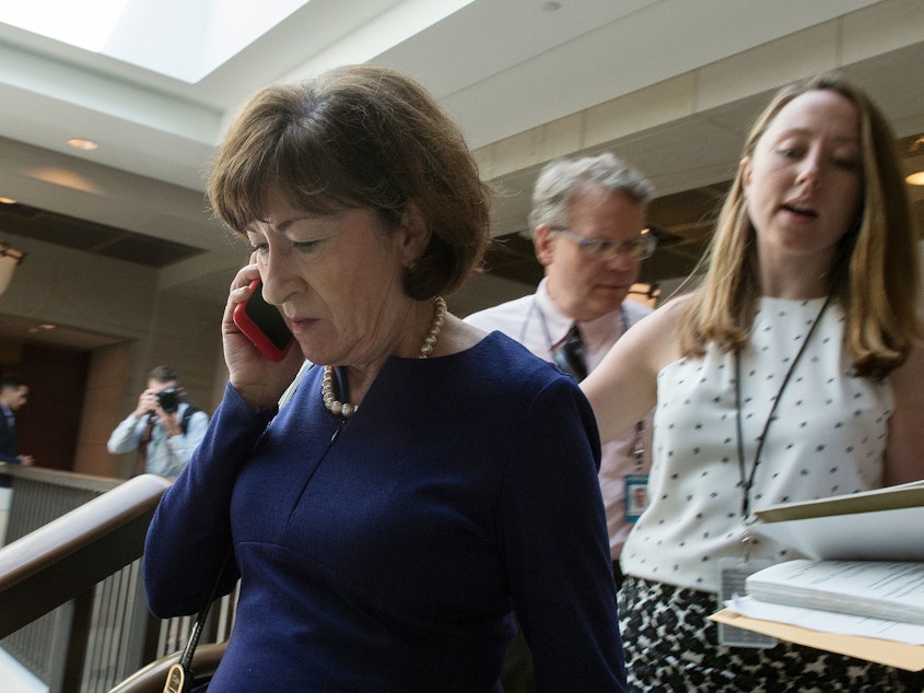 caption: Sen. Susan Collins, R-Maine, talks on a phone while walking to a room on Capitol Hill to read the report on the supplemental FBI investigation into Supreme Court nominee Judge Brett Kavanaugh.