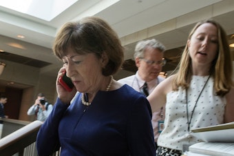 caption: Sen. Susan Collins, R-Maine, talks on a phone while walking to a room on Capitol Hill to read the report on the supplemental FBI investigation into Supreme Court nominee Judge Brett Kavanaugh.