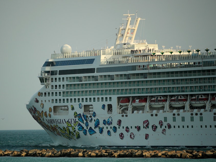 caption: In this file photo, the Norwegian Gem cruise ship leaves the Port of Miami on April 14, 2020 in Miami Beach, Florida. The first trip of the Norwegian Gem after a pandemic-induced hiatus, is scheduled to take off from Miami on Aug. 15.
