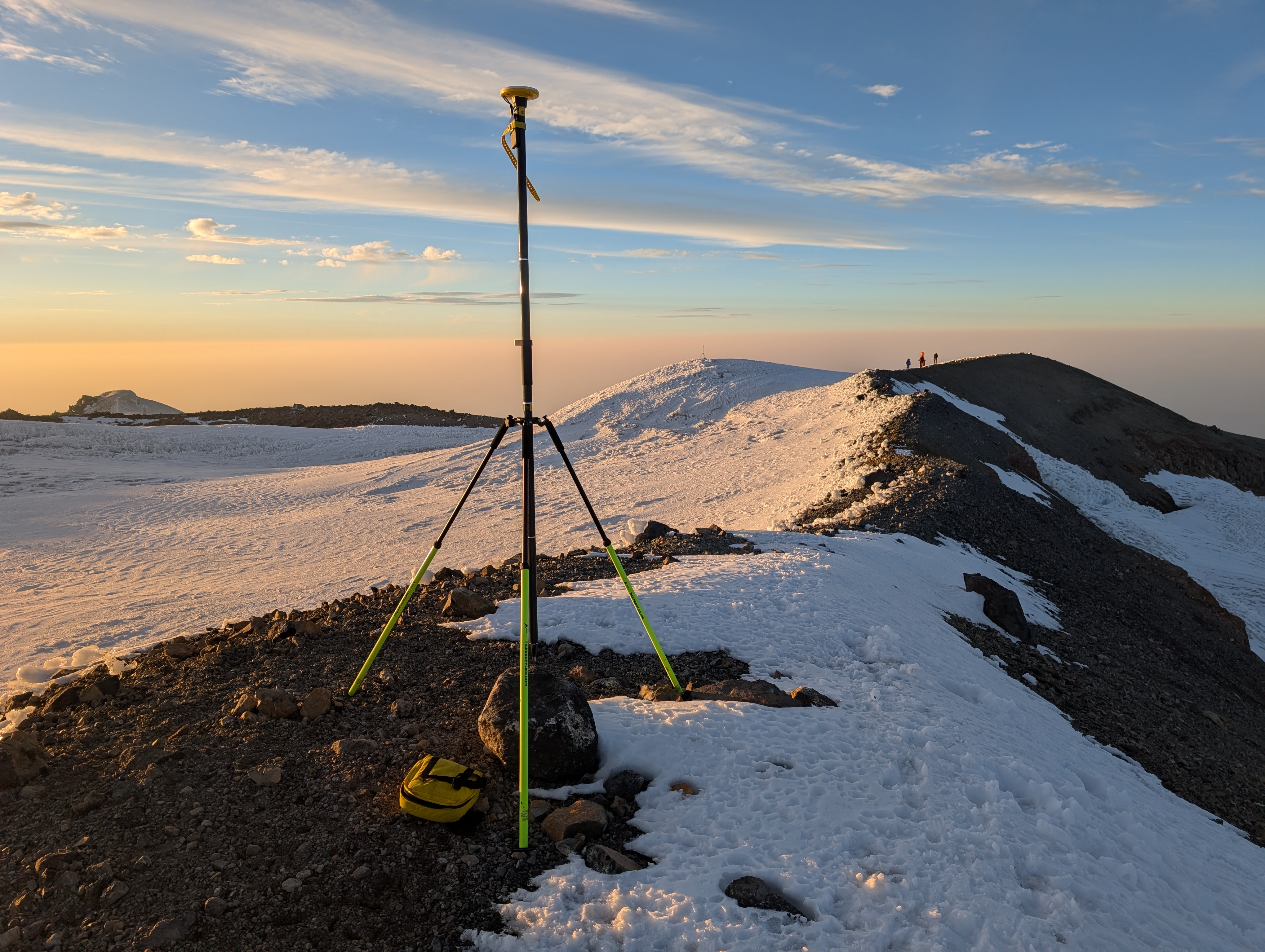 caption: A satellite-linked surveying device stands atop the crater rim of Mount Rainier on Aug. 24, 2025, with Columbia Crest in the background.