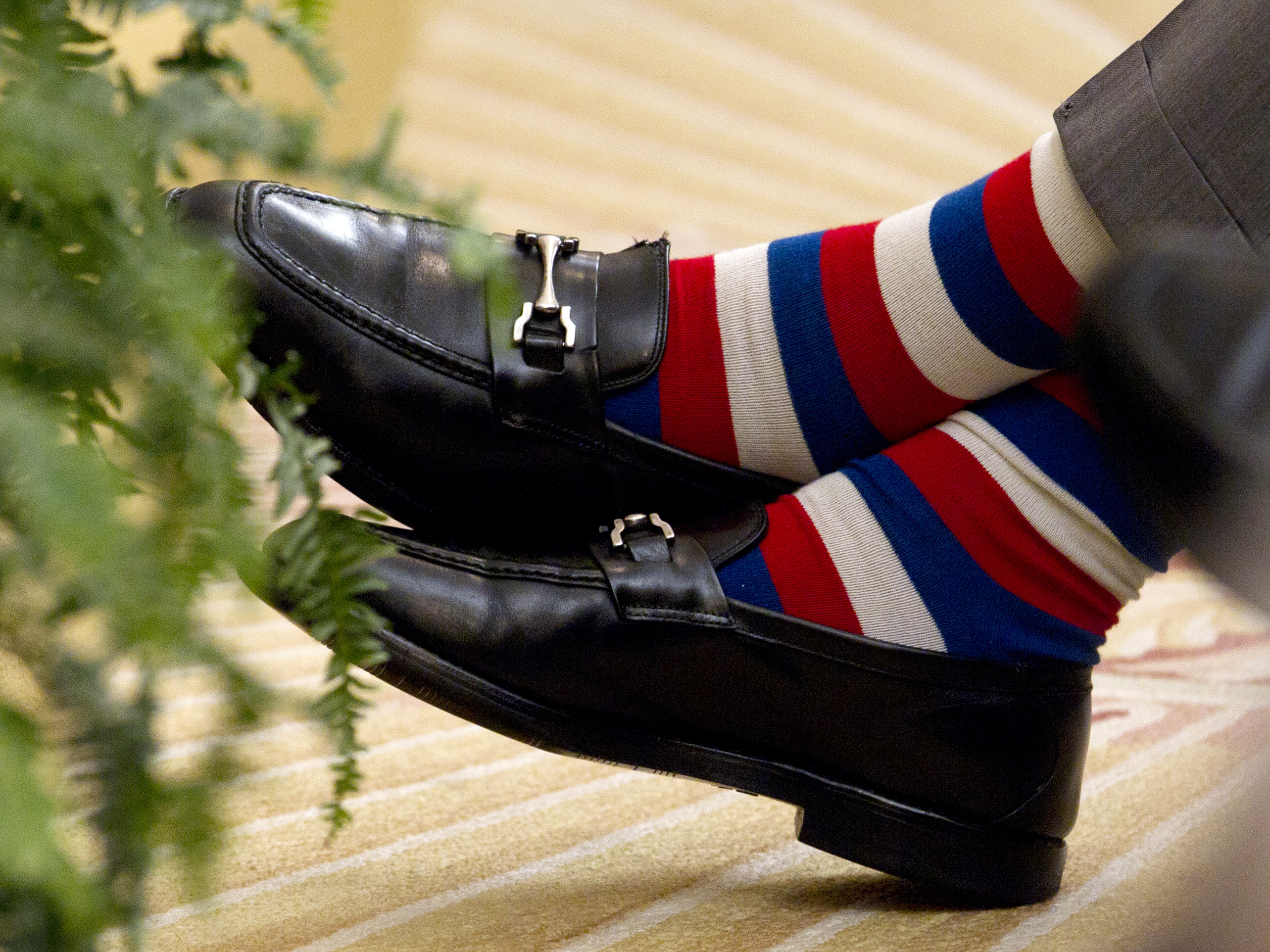 caption: Former President George H.W. Bush crosses his colorfully socked feet during the unveiling ceremony of portraits of his son former President George W. Bush and former first lady Laura Bush, in 2012.