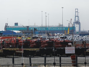 caption: Cars are visible in a general view from the Baltimore Port after the cargo ship Dali ran into and collapsed the Francis Scott Key Bridge in Baltimore, Md., on Tuesday. The accident has temporarily closed the Port of Baltimore, which handles more vehicles per year than any other U.S. port.