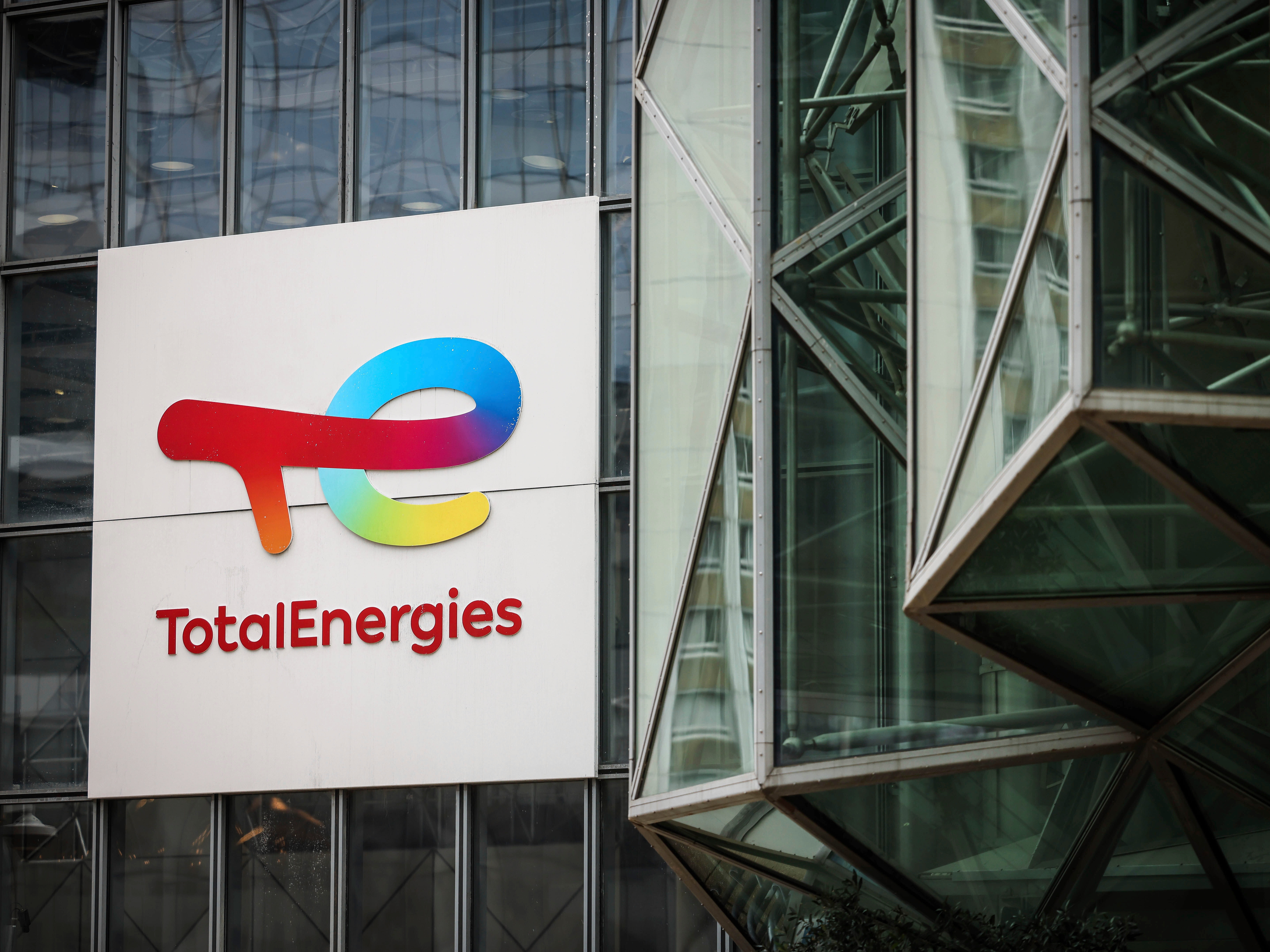 caption: A sign for the French company TotalEnergies is displayed at headquarters March 21, 2025, in La Defense business district outside of Paris.