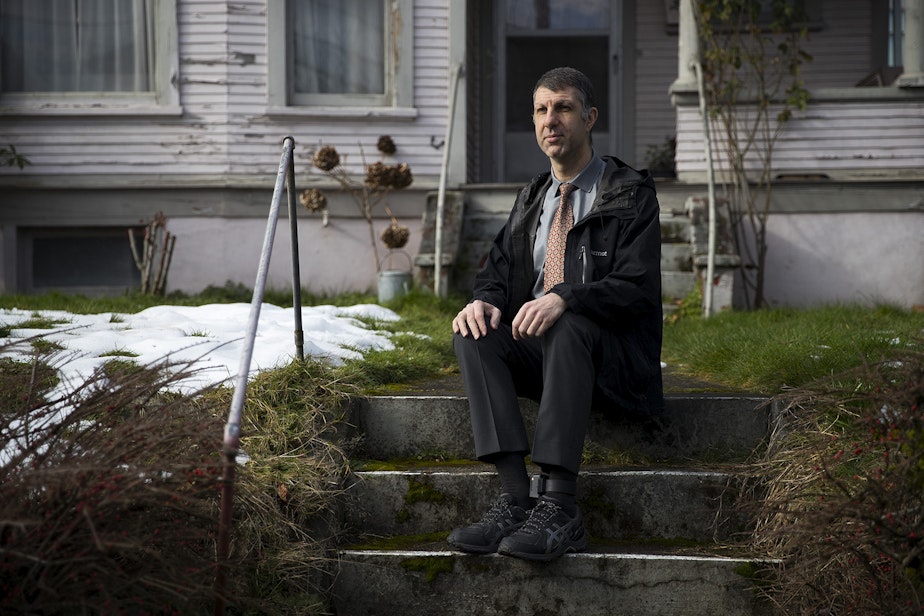 caption: Joe Dibee is portrayed while sitting on steps leading to his family's home on Wednesday, February 17, 2021, in Seattle.