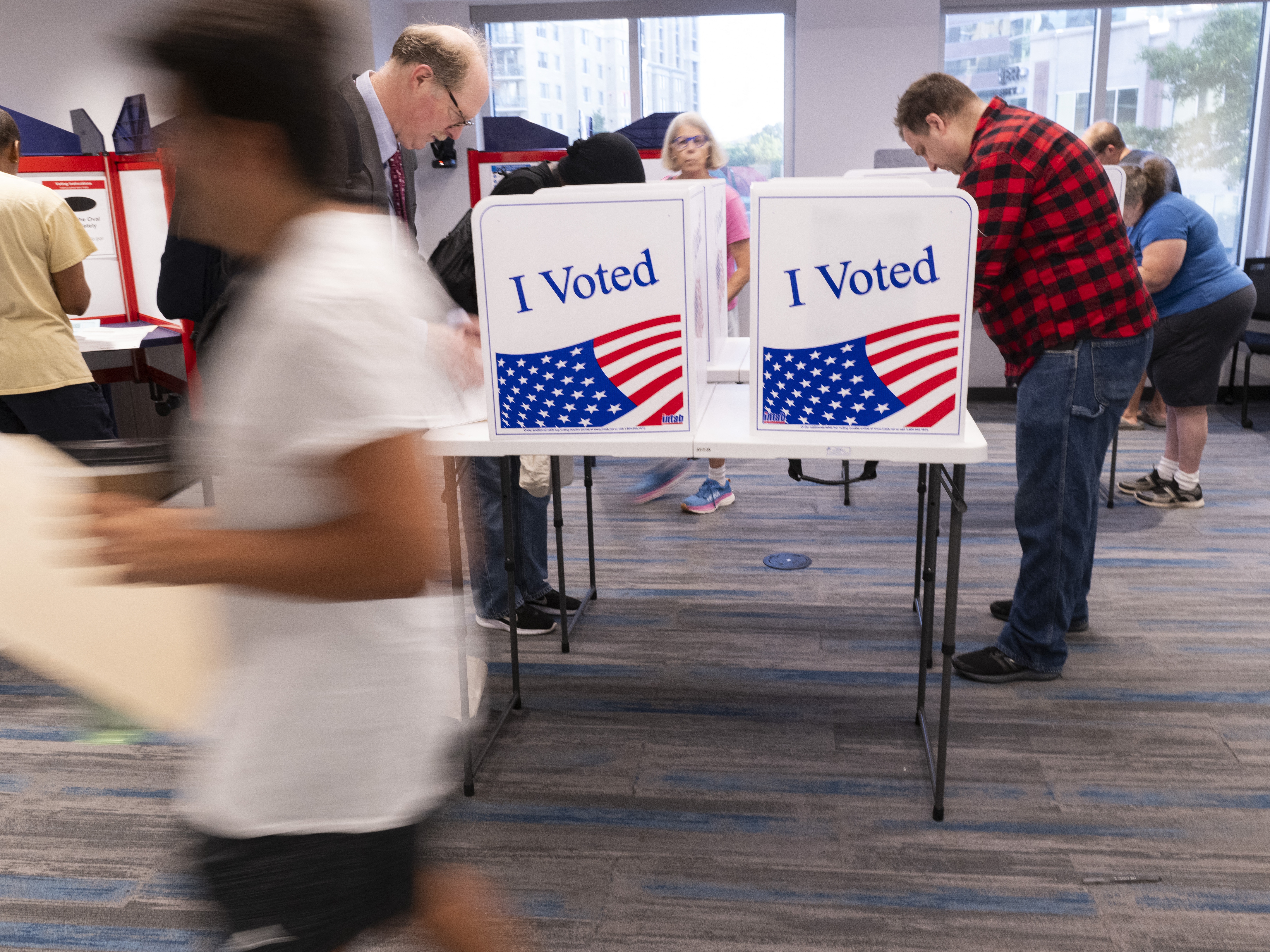 caption: Voters work on their ballots at a polling station in Arlington, Va., on Sept. 20.
