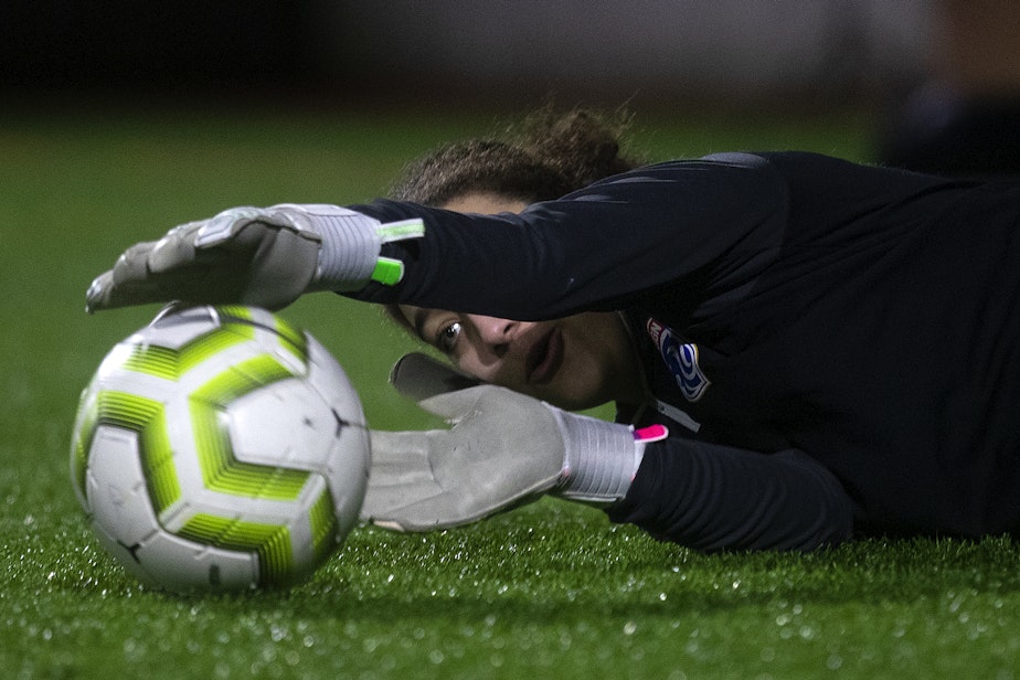 caption: Shaliyah Dupar, 18, dives for a soccer ball during goal keeper training with Seattle Reign Academy on Monday, January 29, 2024, at North SeaTac Park. 