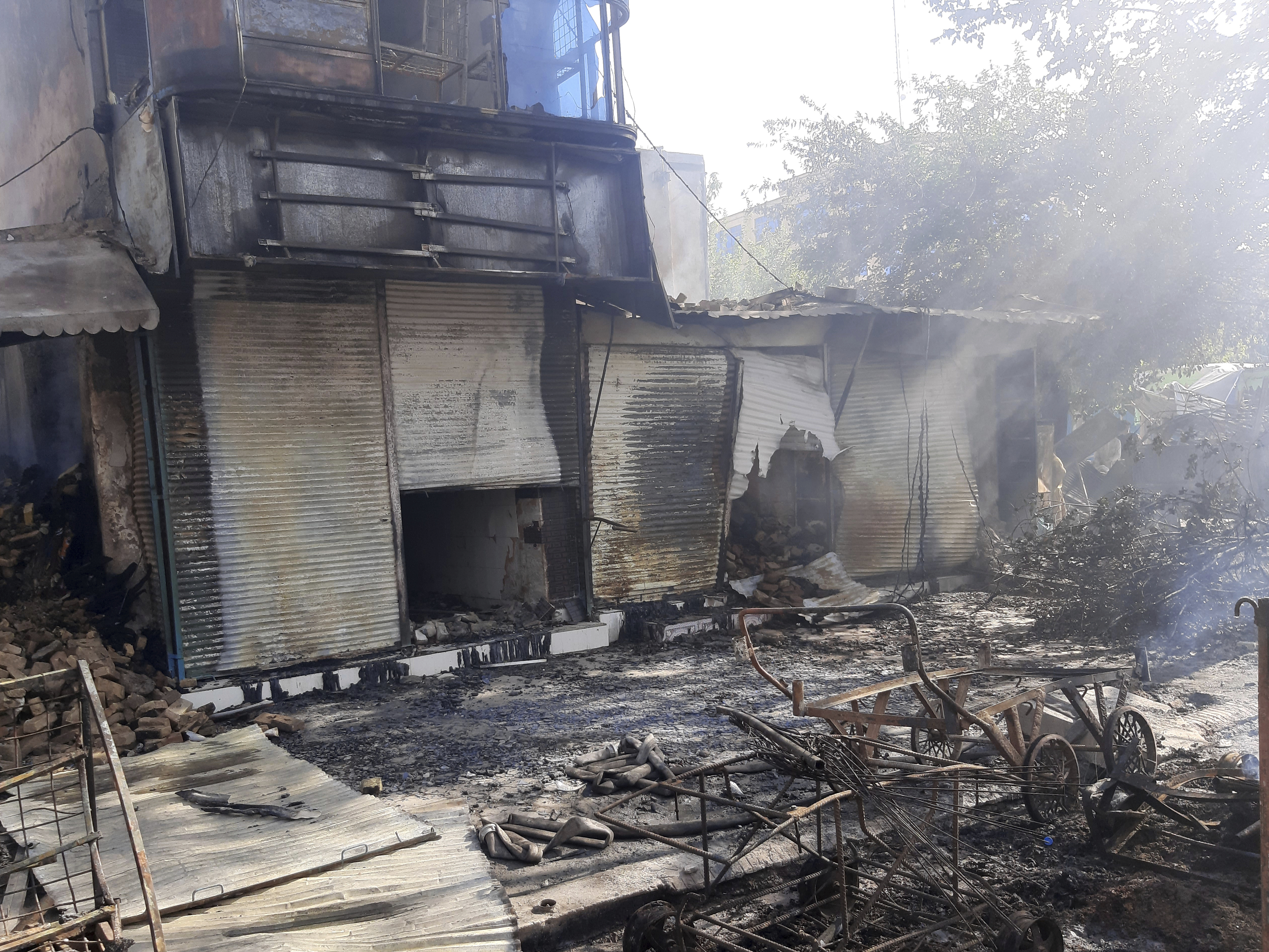 caption: Smoke rises from damaged shops after fighting between Taliban and Afghan security forces in Kunduz city, northern Afghanistan, on Sunday, Aug. 8.
