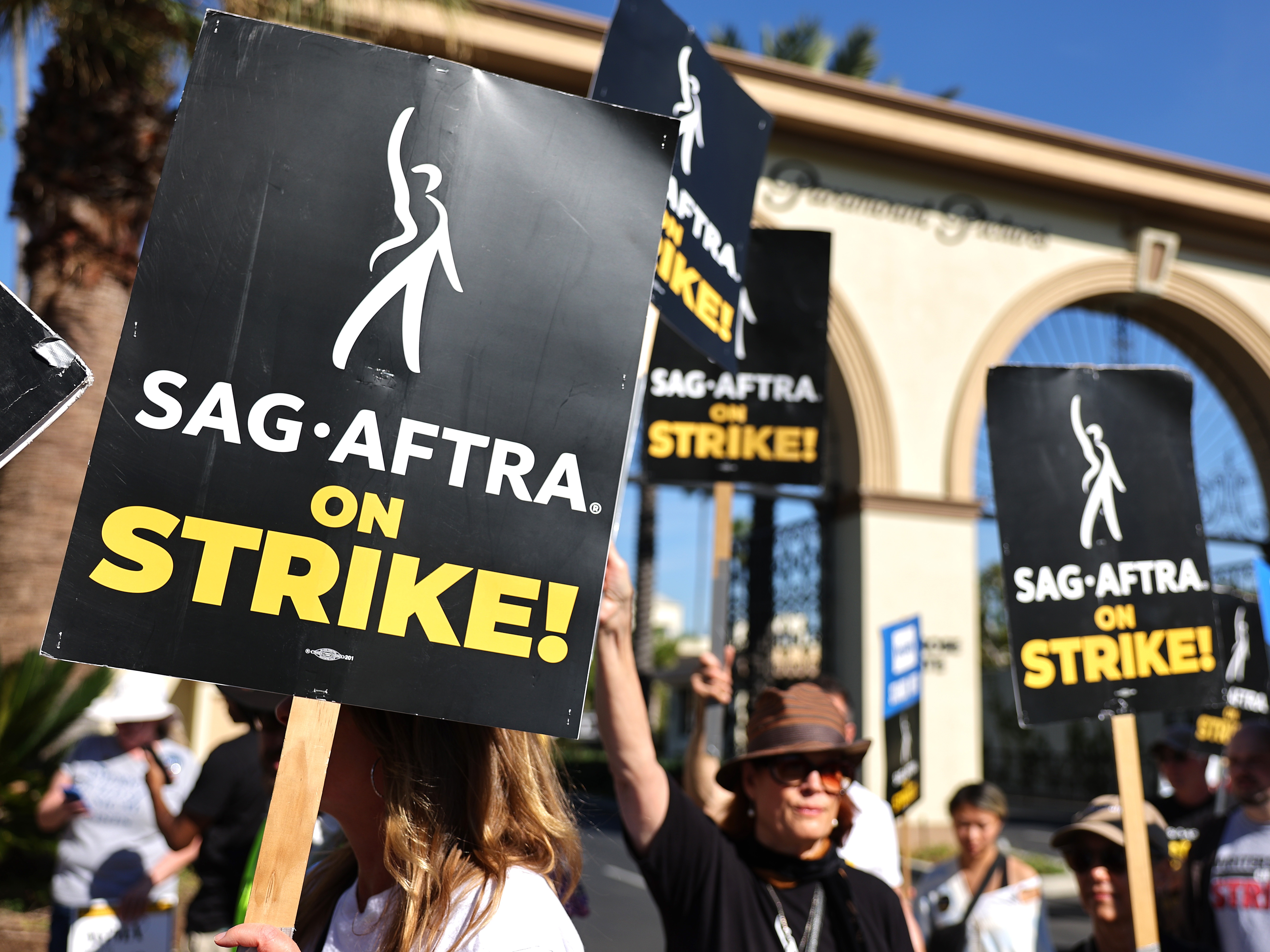 caption: SAG-AFTRA members picket outside Paramount Studios in 2023. Members of the union were on strike between July and November during negotiations with Hollywood film and television studios. Now, the focus is on video games. 