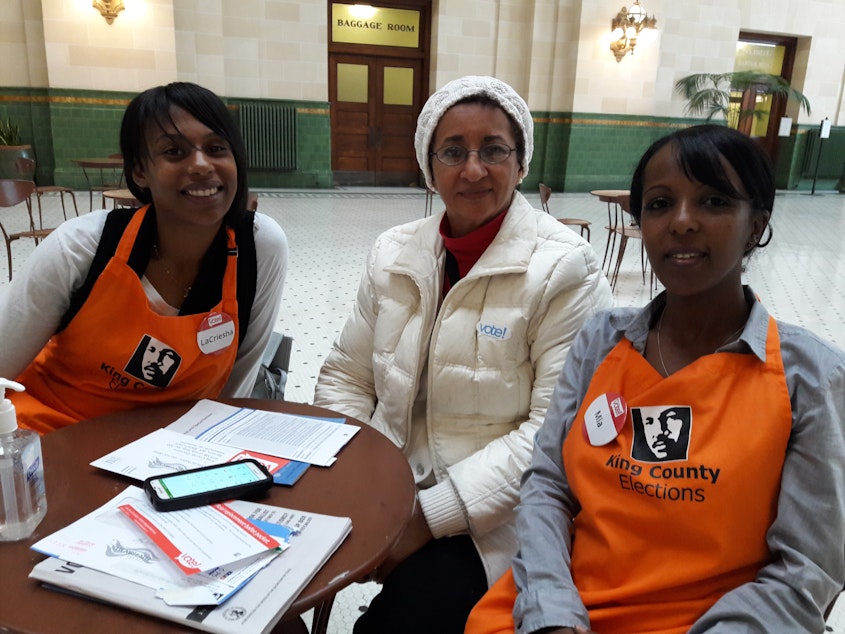 caption: From left: LeCriesha Lewis, Elizabeth Haile and Mia Wolde-Maskell at the Seattle Union Station, one of the few in-person voting centers in King County.