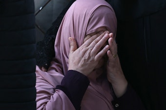 caption: A Palestinian woman mourns after an Israeli airstrike at the Rafah refugee camp, in the southern Gaza Strip on Tuesday.