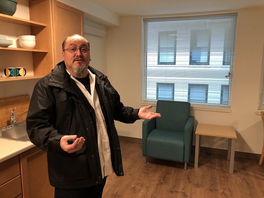 caption: Derrick Belgarde with the Chief Seattle Club shows off new housing units next door in Pioneer Square.