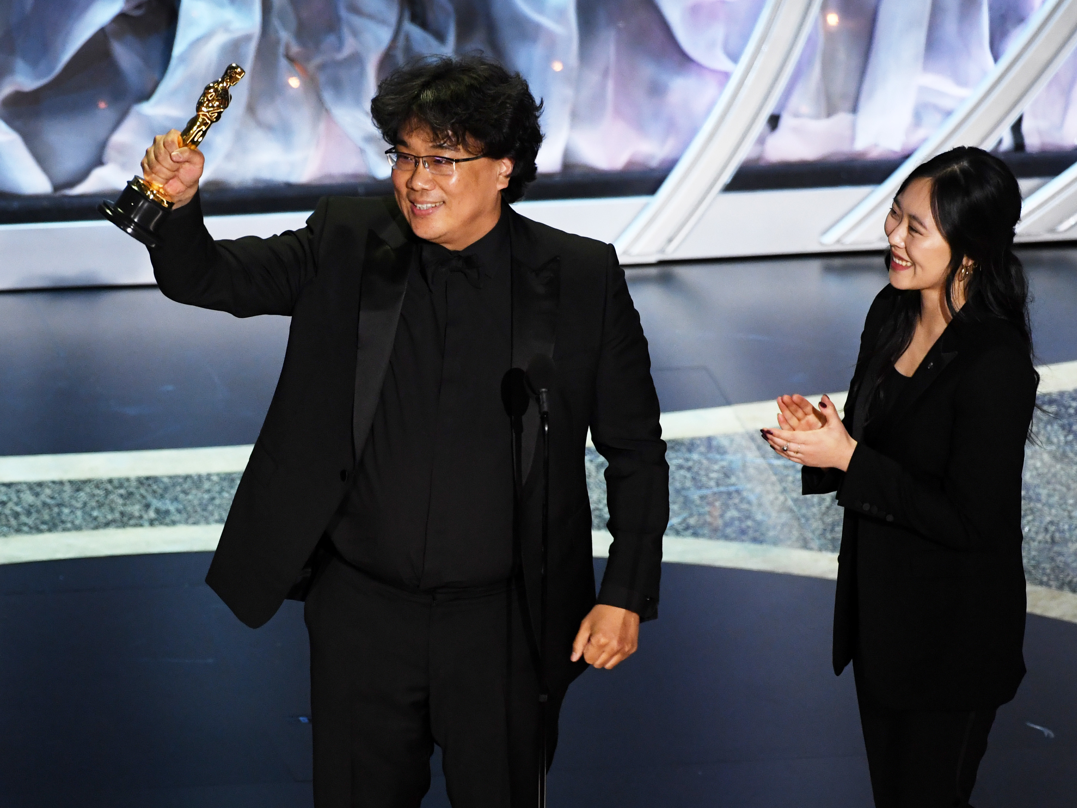 caption: Bong Joon-ho, here with interpreter Sharon Choi, won big at Sunday's Oscars. His film <em>Parasite</em> took best international feature and best picture, and he was recognized for his direction and writing.