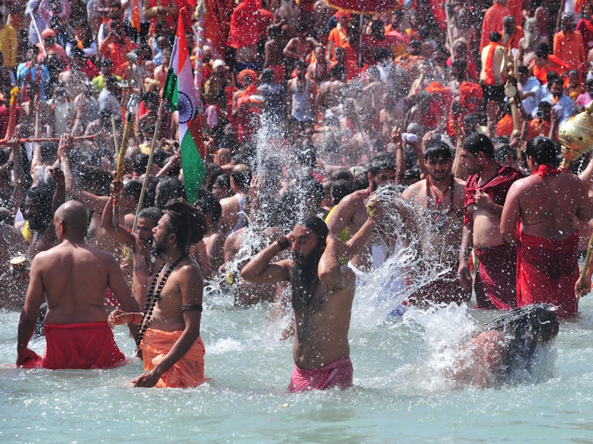 caption: Men take a holy dip in the Ganges River on the occasion of first royal bath of Shivratri festival during Maha Kumbh Festival in Haridwar, India.