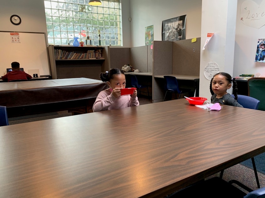 caption: Sisters Queen-Alini Ropati Vao, 9, and Britta Ropati Vao, 5, eat breakfast at CAYA before remote school starts.