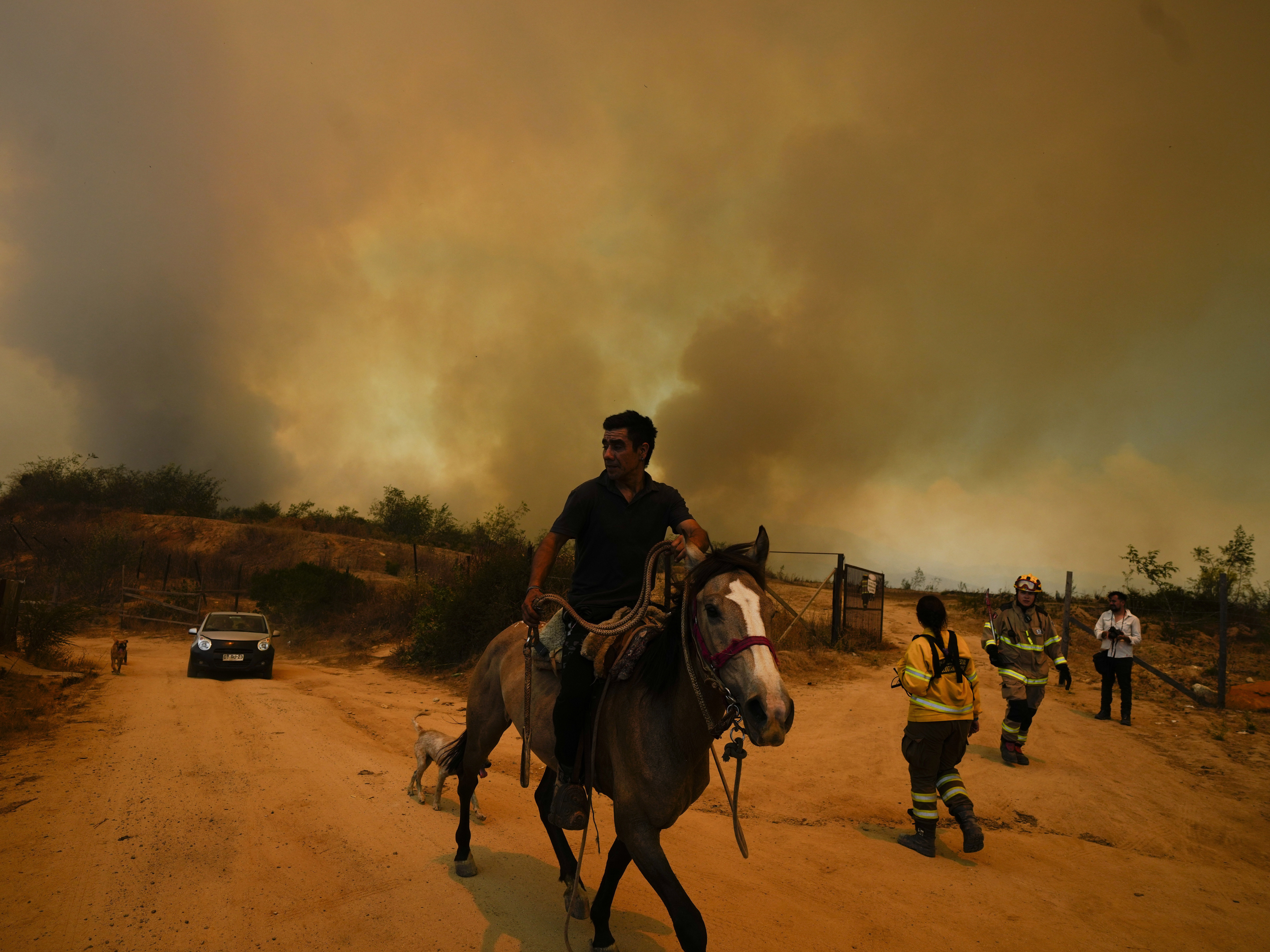 caption: A resident flees an encroaching forest fire in Vina del Mar, Chile, on Saturday. Officials say intense forest fires burning around a densely populated area of central Chile have left several people dead and destroyed hundreds of homes.