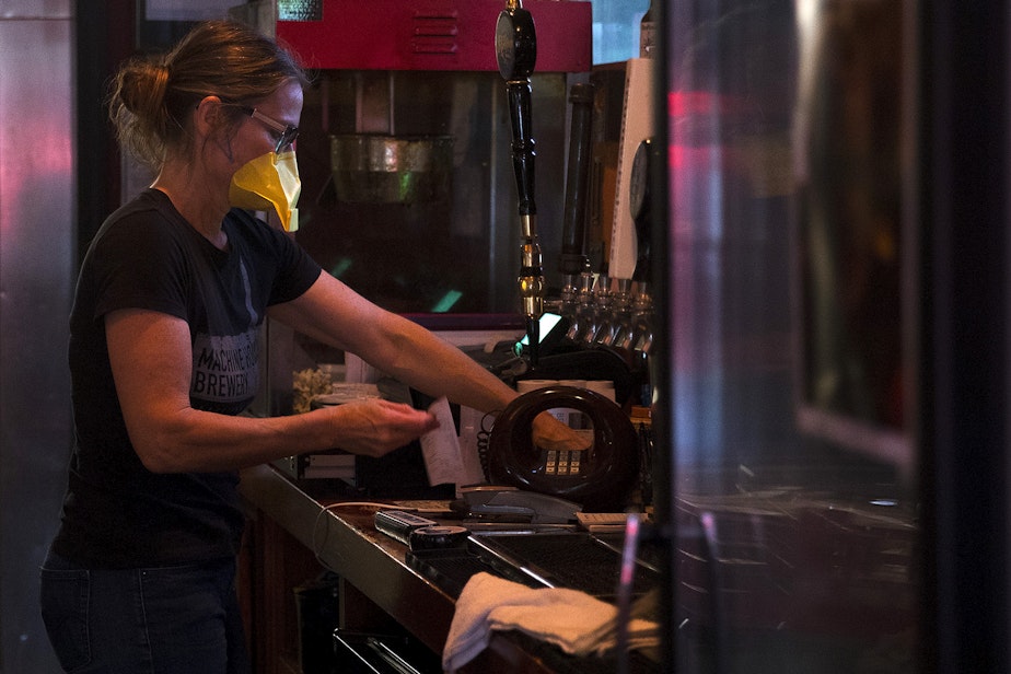 caption: Co-owner of the Tippe and Drague Alehouse, Melissa Cabal, works behind the bar on Friday, July 24, 2020, on Beacon Avenue South in Seattle.