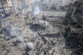 caption: Palestinians inspect the damage following an Israeli airstrike on the Sousi mosque in Gaza City on Monday.