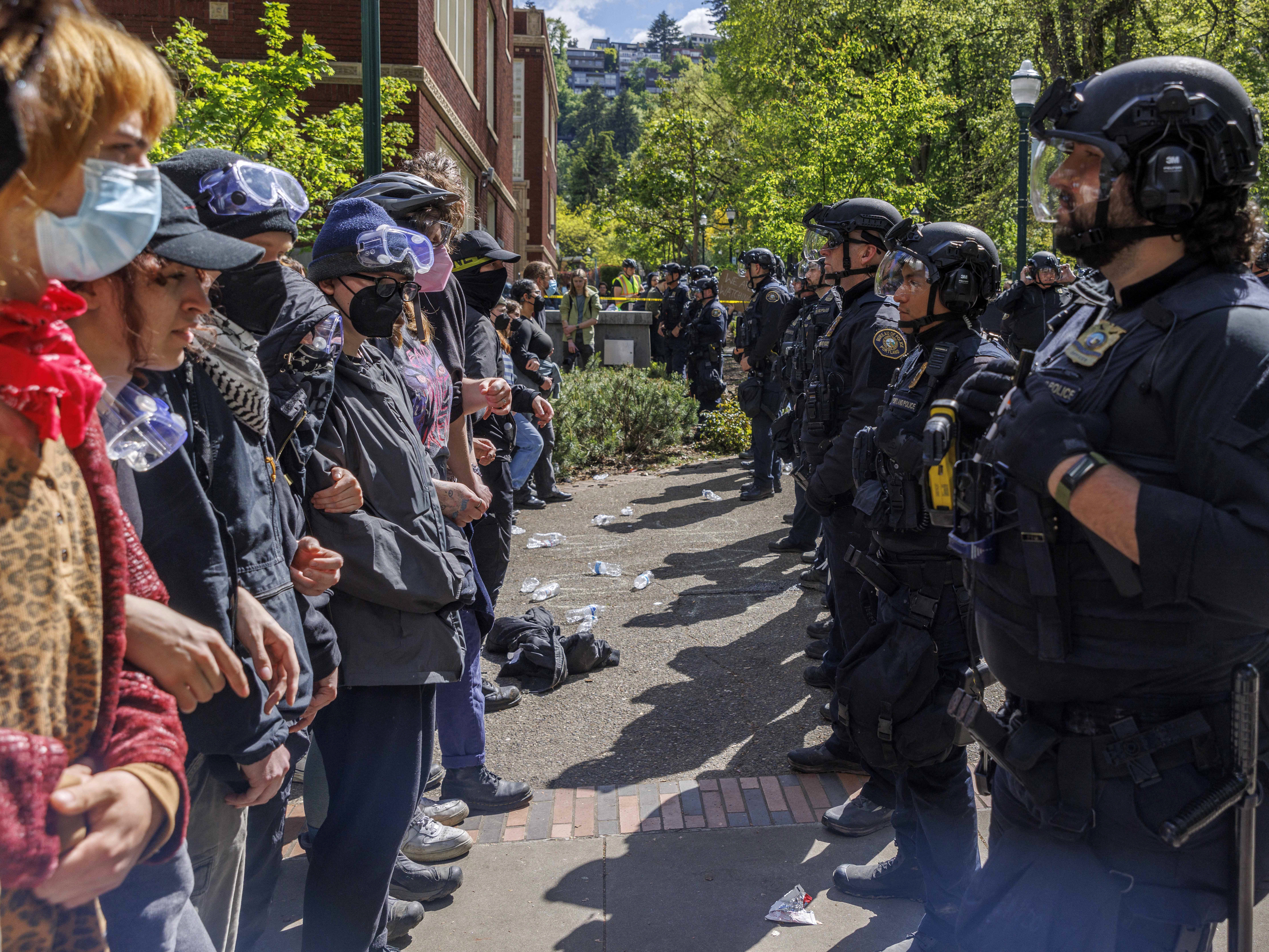 caption: Pro-Palestinian students and activists face police officers after protesters were evicted from the library at Portland State University in Portland, Ore., in May.
