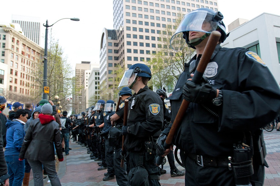 caption: Seattle Police form a barricade on May 1, 2012. As a result of the May Day protests, a federal courthouse was vandalized. Two people who were not present at the protests were found in contempt of court for not testifying about the events. 