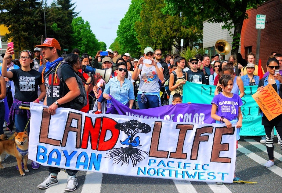 caption: People walk in the May Day labor march in Seattle on Friday.