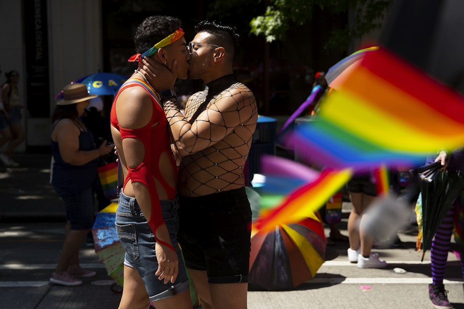 caption: Chrissy, left, and Andres, right, share a kiss while marching with Entre Hermanos, Seattle’s Latinx LGBTQ+ organization, during Seattle’s Pride Parade on Sunday, June 25, 2023, in downtown Seattle. 