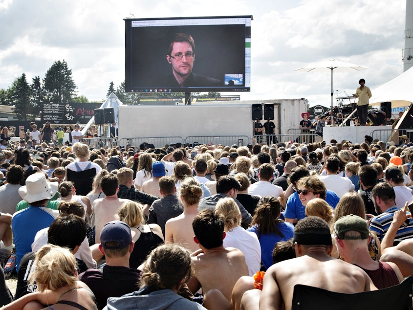 caption: Former NSA contractor Edward Snowden, on a video link in Moscow, speaks to the crowd on a giant screen at festival in Roskilde, Denmark, in 2016. "You are being watched all the time and you have no privacy," Snowden said.