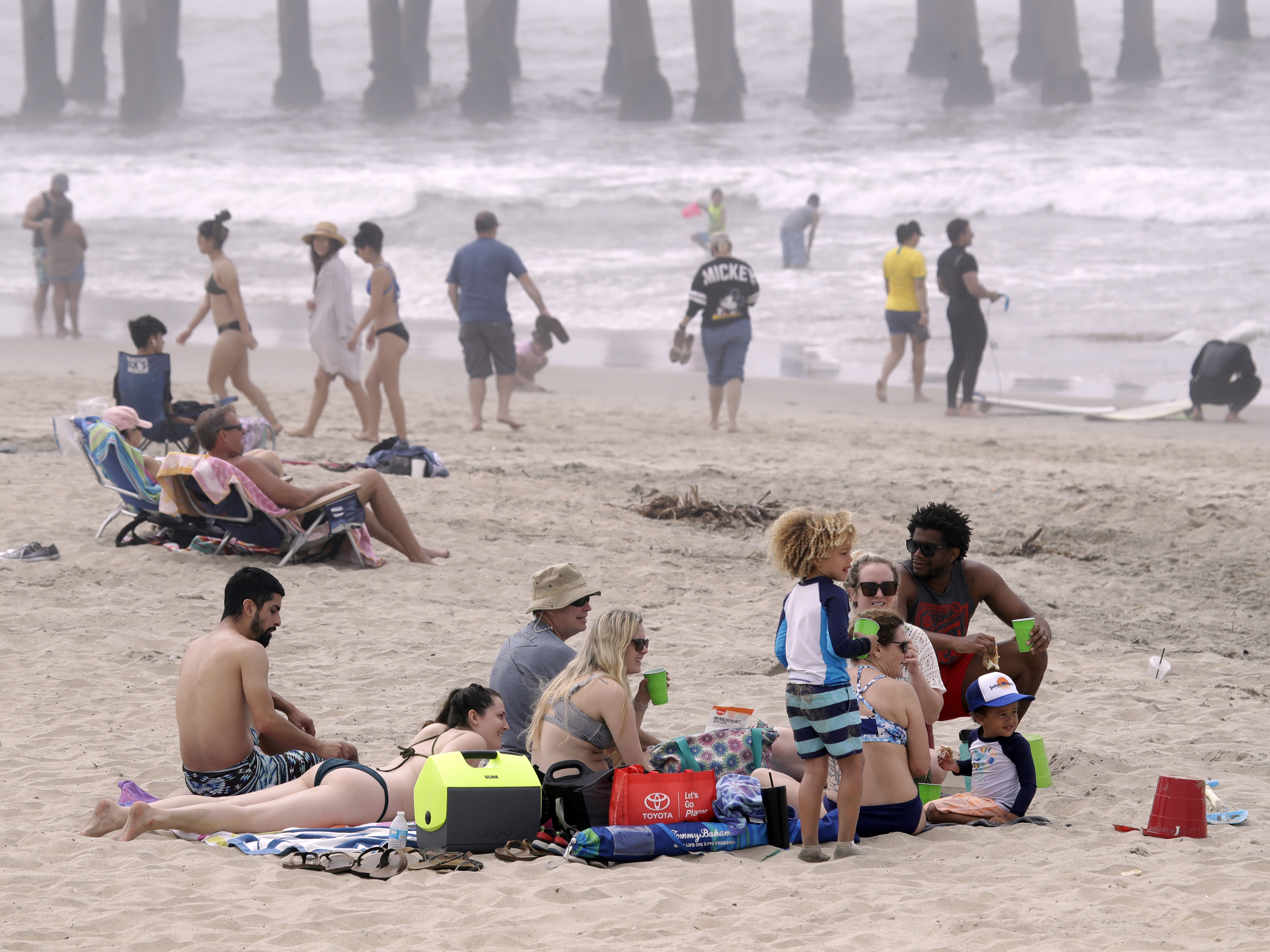 caption: People enjoy a day out on Sunday in Huntington Beach, Calif. High numbers of beachgoers over the weekend prompted warnings from officials that defying stay-at-home orders could reverse progress and bring the coronavirus surging back.