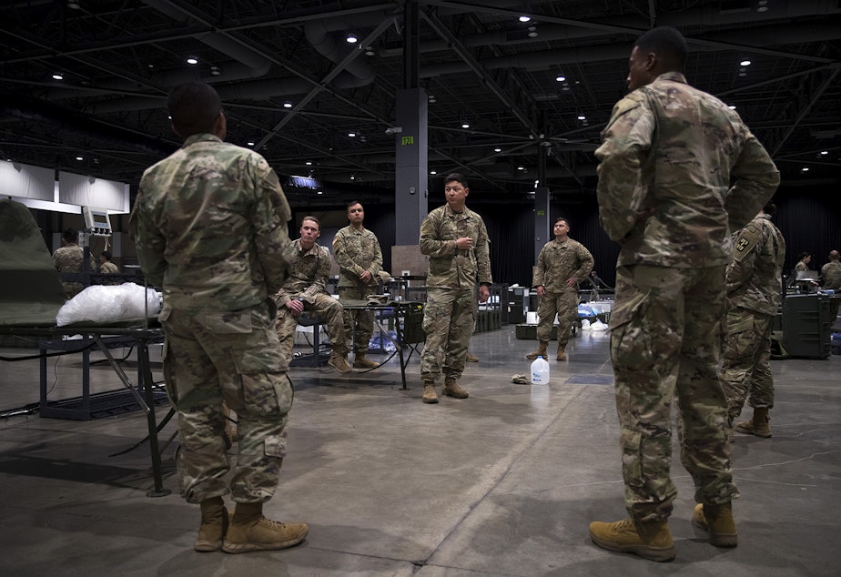 caption: U.S. Army soldiers from the 627th Army Hospital from Fort Carson, Colorado, as well as from Joint Base Lewis-McChord set up a 250-bed military field hospital for non COVID-19 patients on Tuesday, March 31, 2020, at the CenturyLink Field Event Center in Seattle.