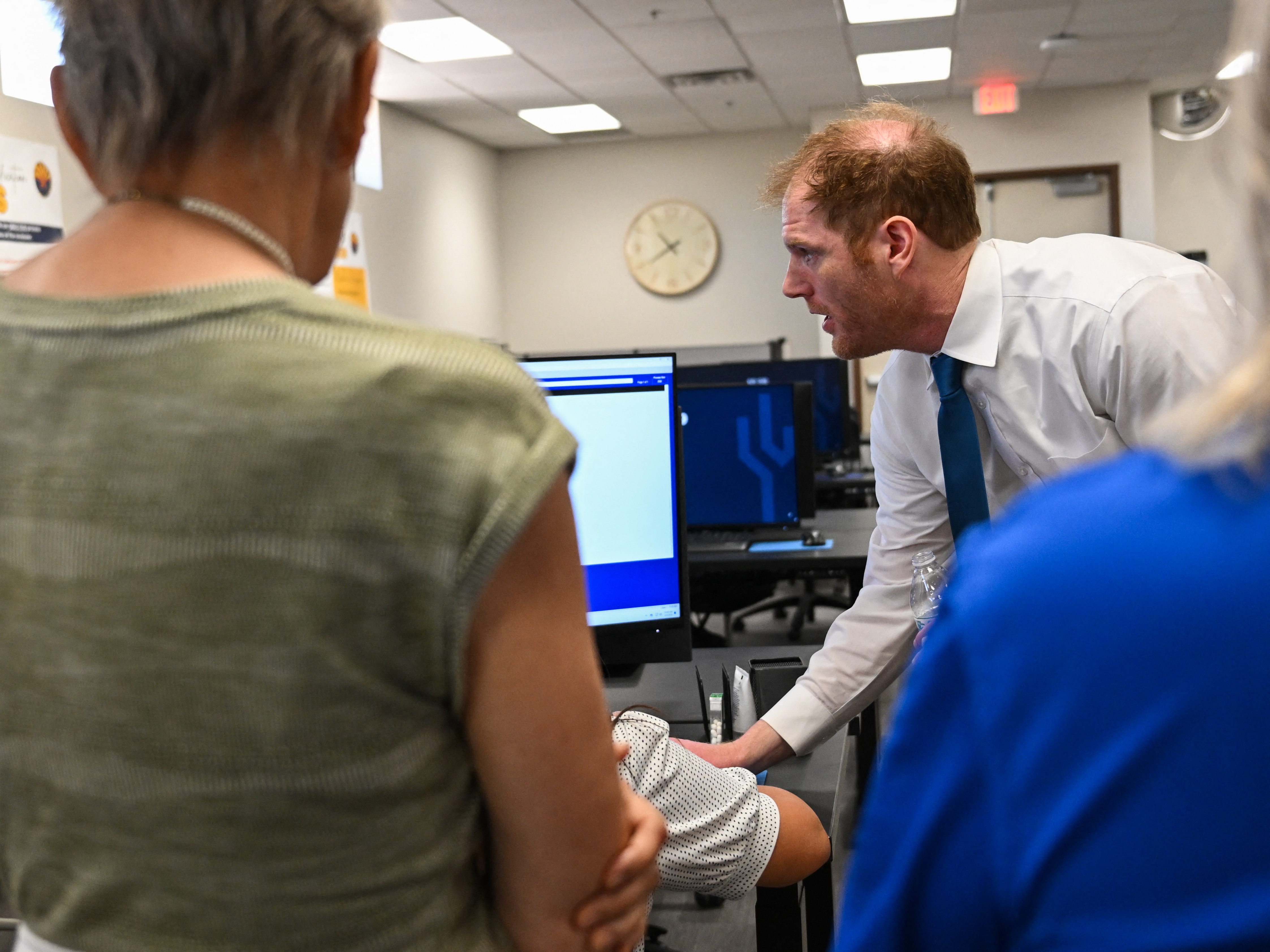 caption: Maricopa County Recorder Stephen Richer demonstrates signature verification for early voting ballots to a tour group of Republican women on June 3 in Phoenix. Richer himself faces primary challengers this month.