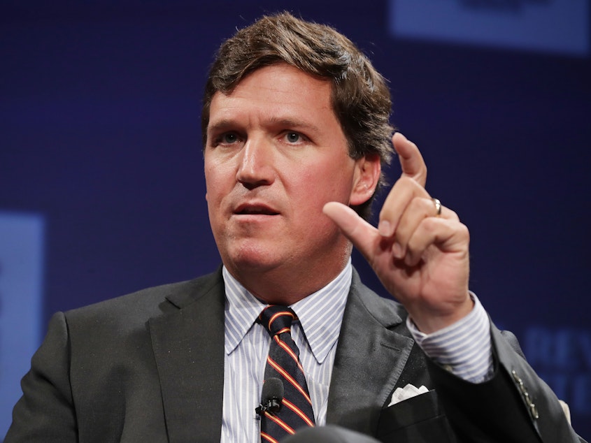 caption: Fox News host Tucker Carlson speaks at a National Review Institute event on March 29, 2019 in Washington, DC. The network abruptly announced it would "part ways" with Carlson on Monday.
