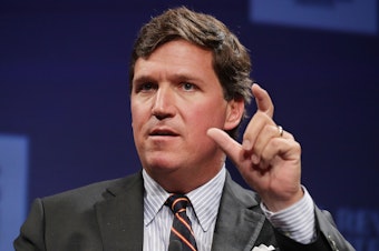 caption: Fox News host Tucker Carlson speaks at a National Review Institute event on March 29, 2019 in Washington, DC. The network abruptly announced it would "part ways" with Carlson on Monday.