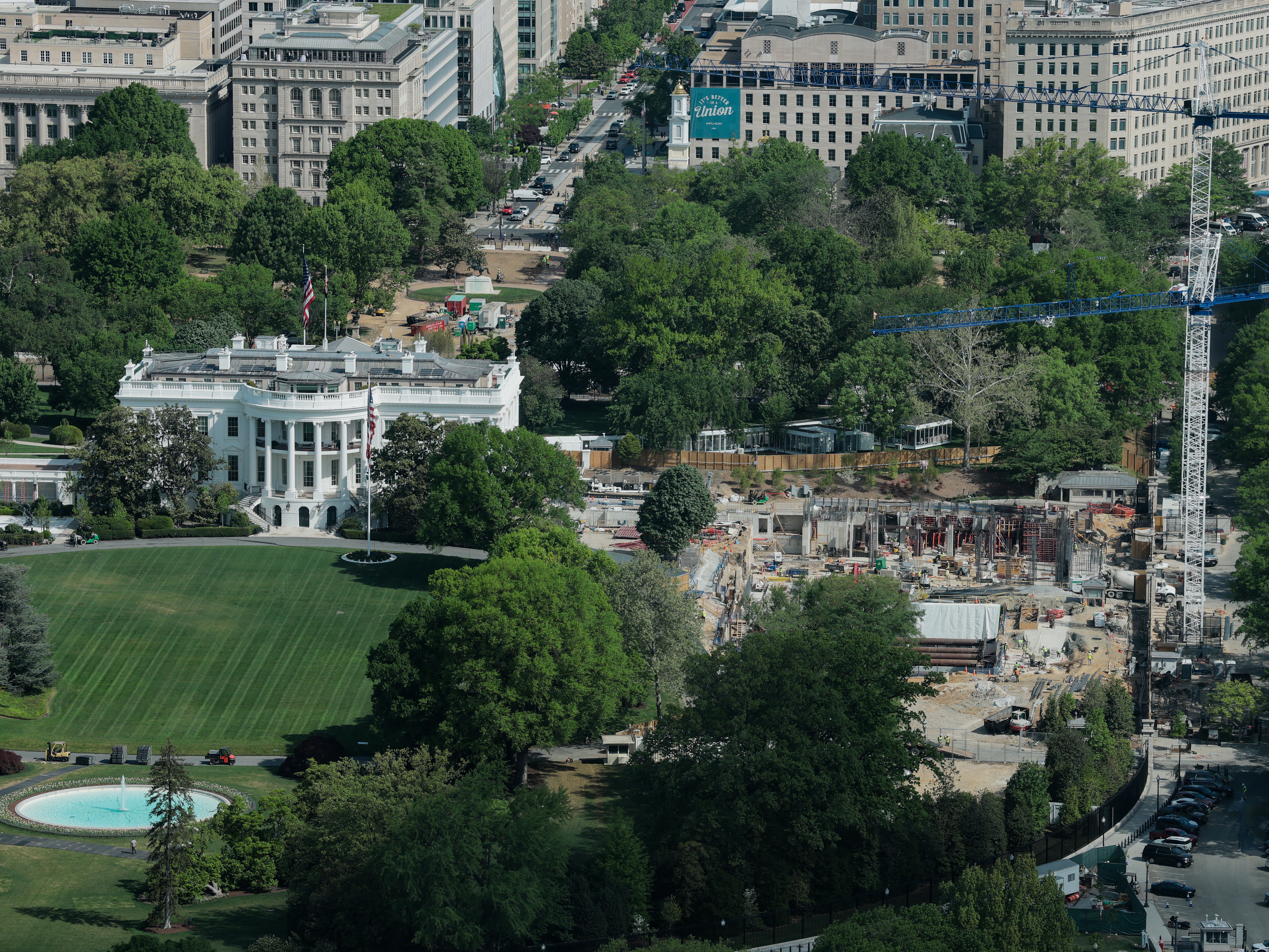 caption: Construction cranes are seen, from the Washington Monument, on the site of the former East Wing of the White House on April 17, 2026 in Washington, DC.