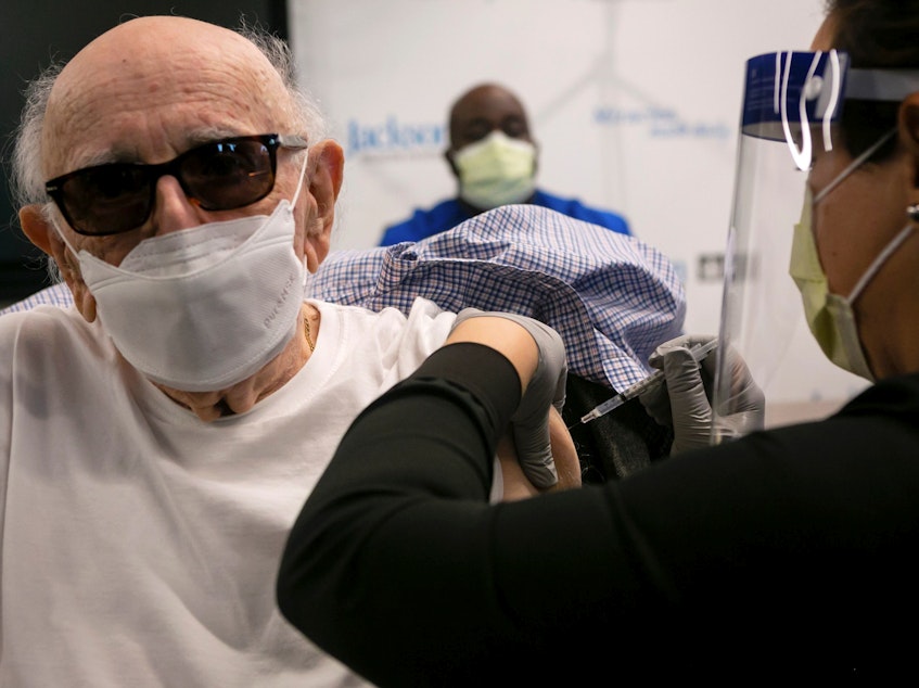 caption: Norman Einspruch, 88, a cardiology patient at Jackson Memorial Hospital in Miami, Fla., receives his first dose of the Pfizer-BioNtech COVID-19 vaccine Dec. 30.