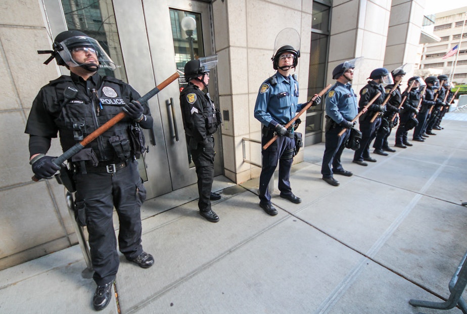 caption: Seattle Police guard a building during protests on Dec. 6, 2014, in response to the killings of Michael Brown in Missouri and Eric Garner in New York.