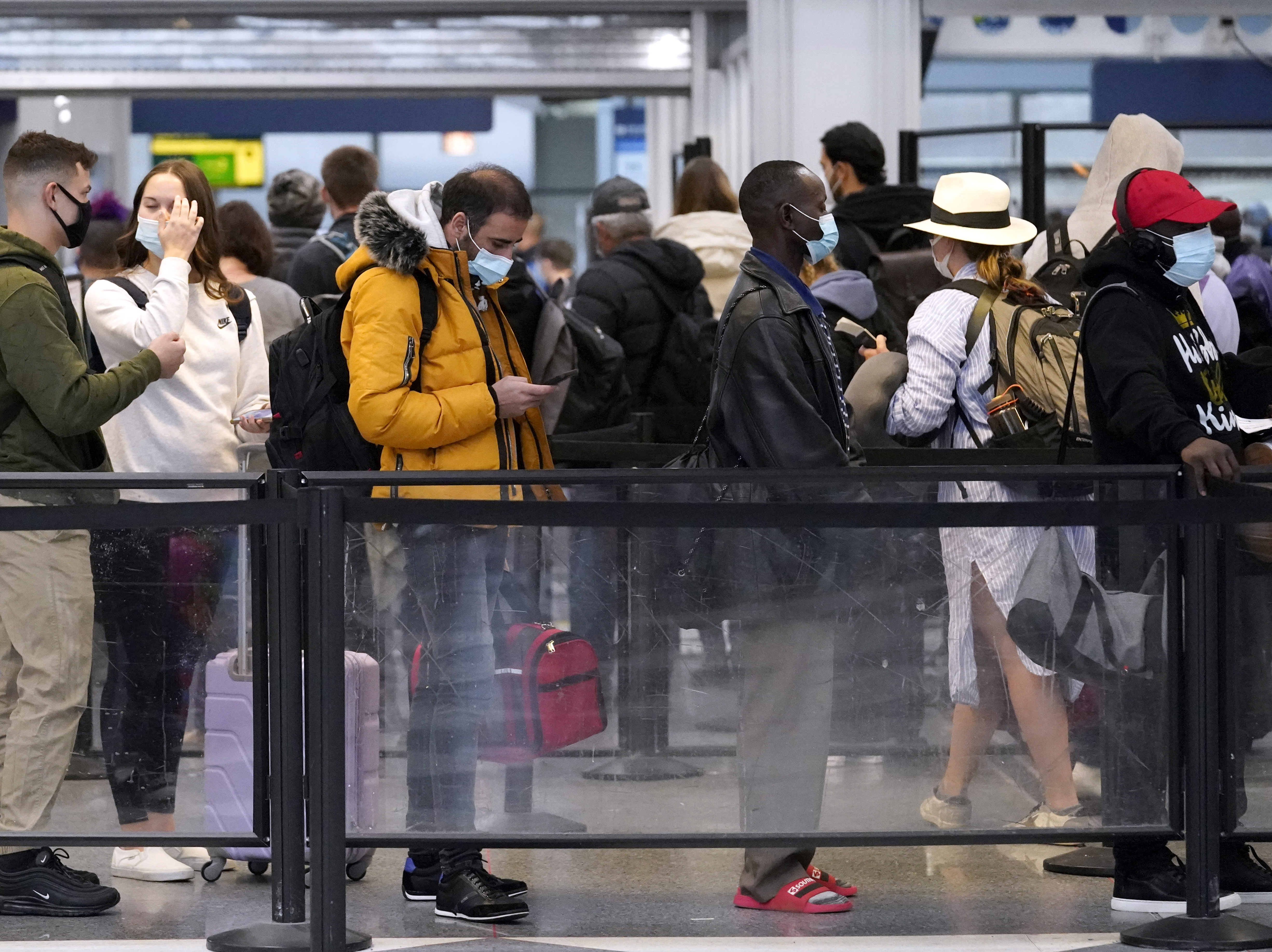 caption: Travelers line up for flights at O'Hare International Airport in Chicago on Thursday.