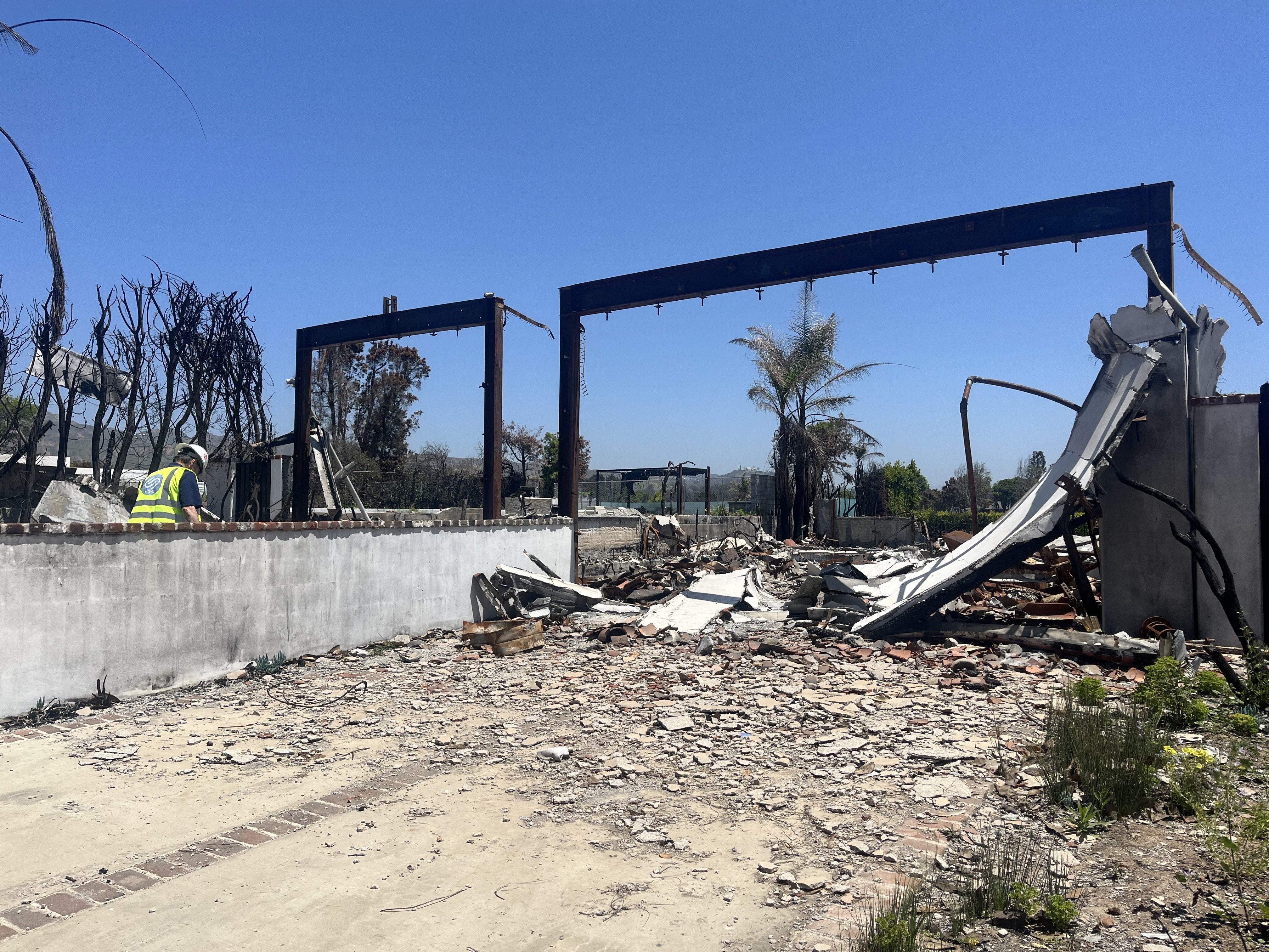 caption: More than 16,000 structures burned in the Los Angeles fires, many of them homes. A lot in Pacific Palisades, Calif., has yet to be cleared.