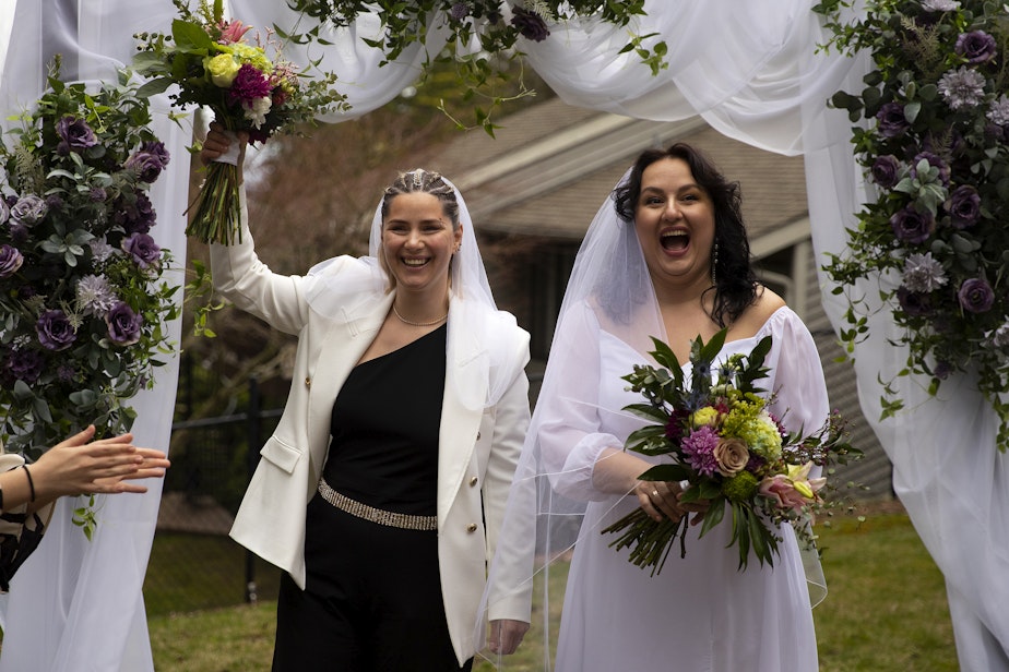 caption: Iryna, left, and Olena, smile at their wedding guests shortly after getting married on Saturday, April 8, 2023, at a home in Bellevue. 