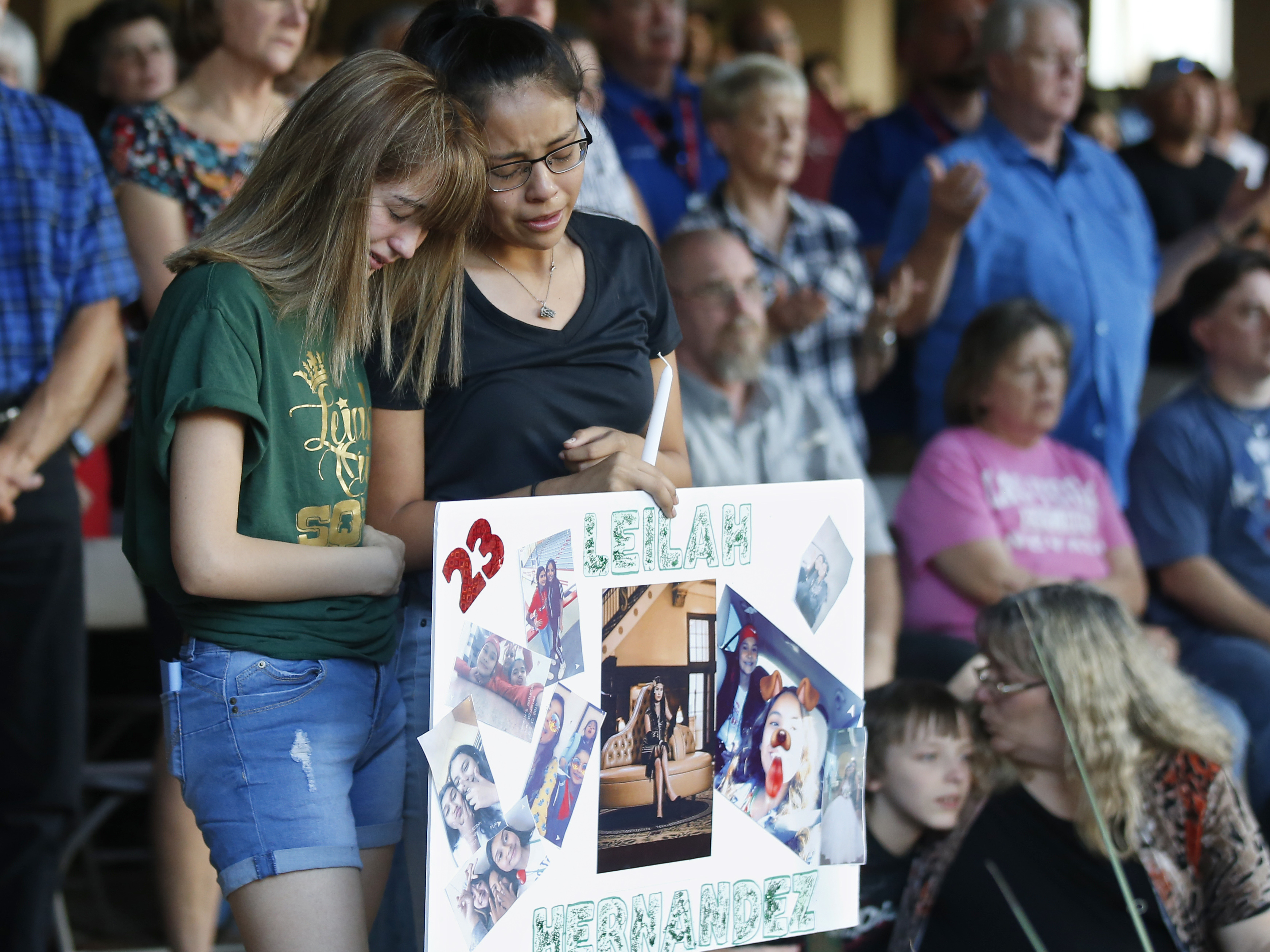 caption: High School students Celeste Lujan, left, and Yasmin Natera mourn their friend, Leila Hernandez, one of the victims of the Saturday shooting in Odessa, Texas, at a memorial service on Sunday.
