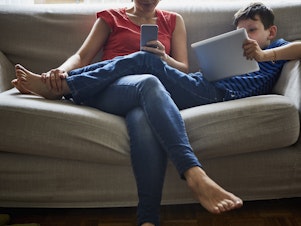 caption:  The biggest predictor of screen time for kids is how much their parents use their devices, a new study finds.