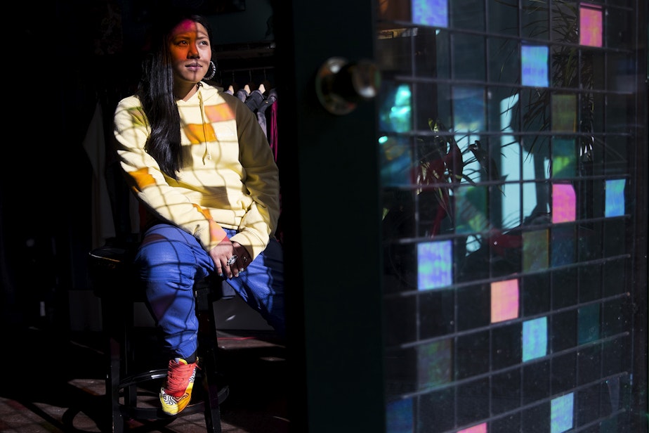 caption: Karleen Ilagan, owner of Moksha, poses for a portrait in the light shining through a colorful grill that was put in place to deter burglars at the store on Thursday, February 21, 2019, in Seattle. 