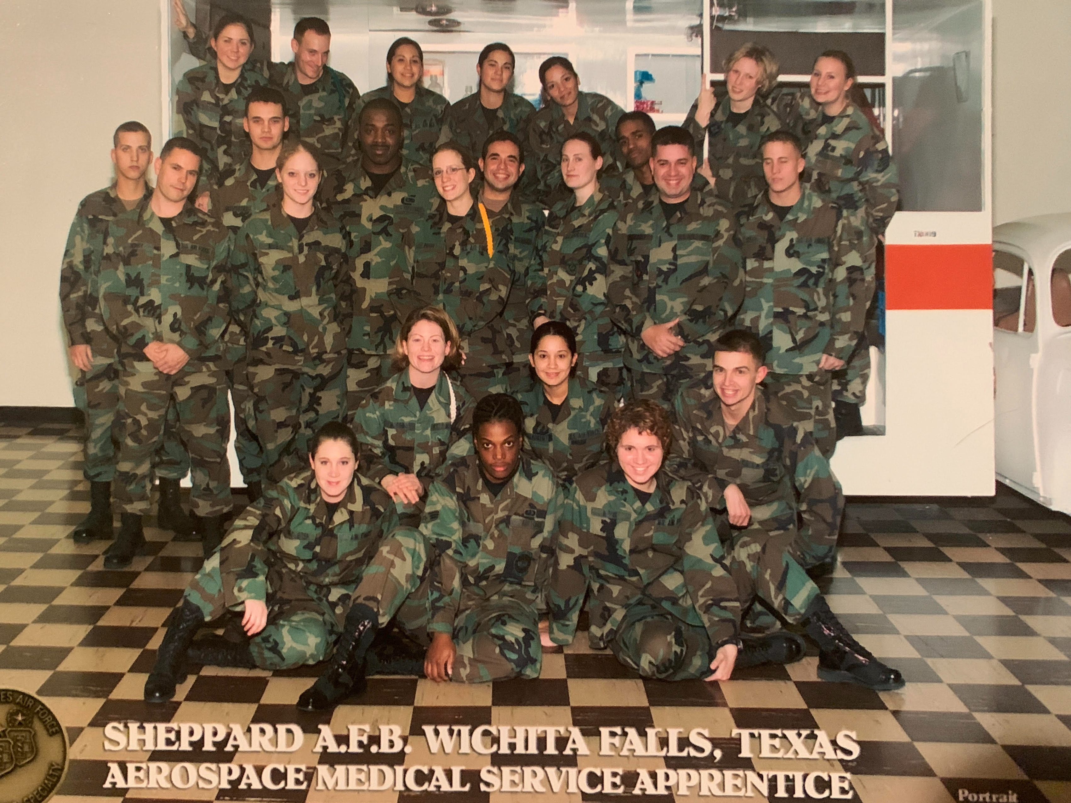 caption: Jessica Israelsen (first from the left in the second row from bottom) in 2003, when she first joined the U.S. Air Force as a medical technician. In 2008, when she was struggling financially, her unit purchased Christmas gifts for her family.