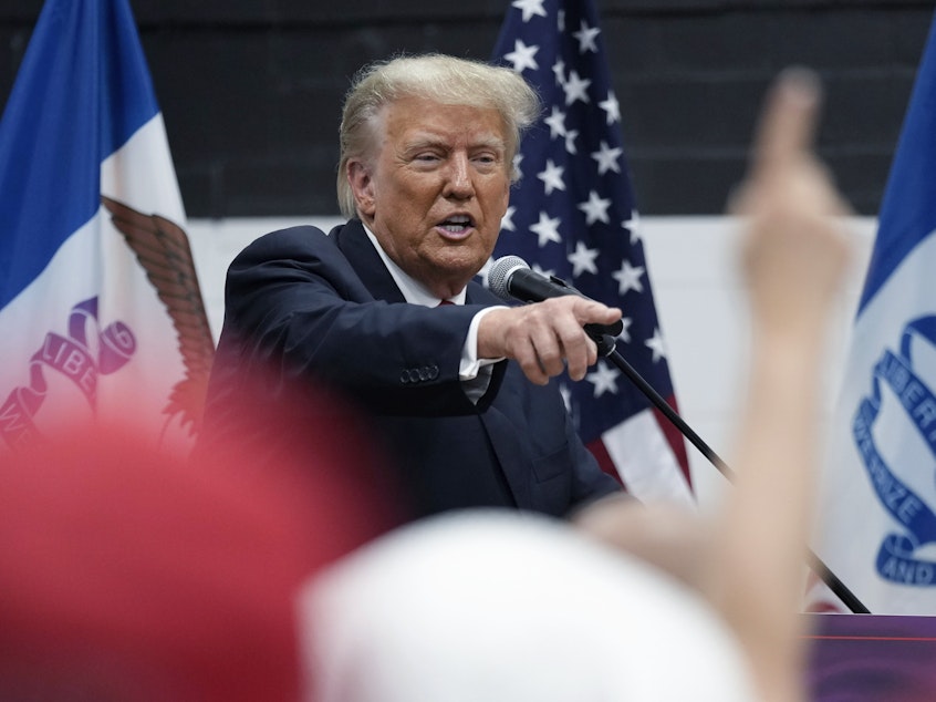 caption: Former President Donald Trump visits with campaign volunteers at the Grimes Community Complex Park on June 1 in Des Moines, Iowa.