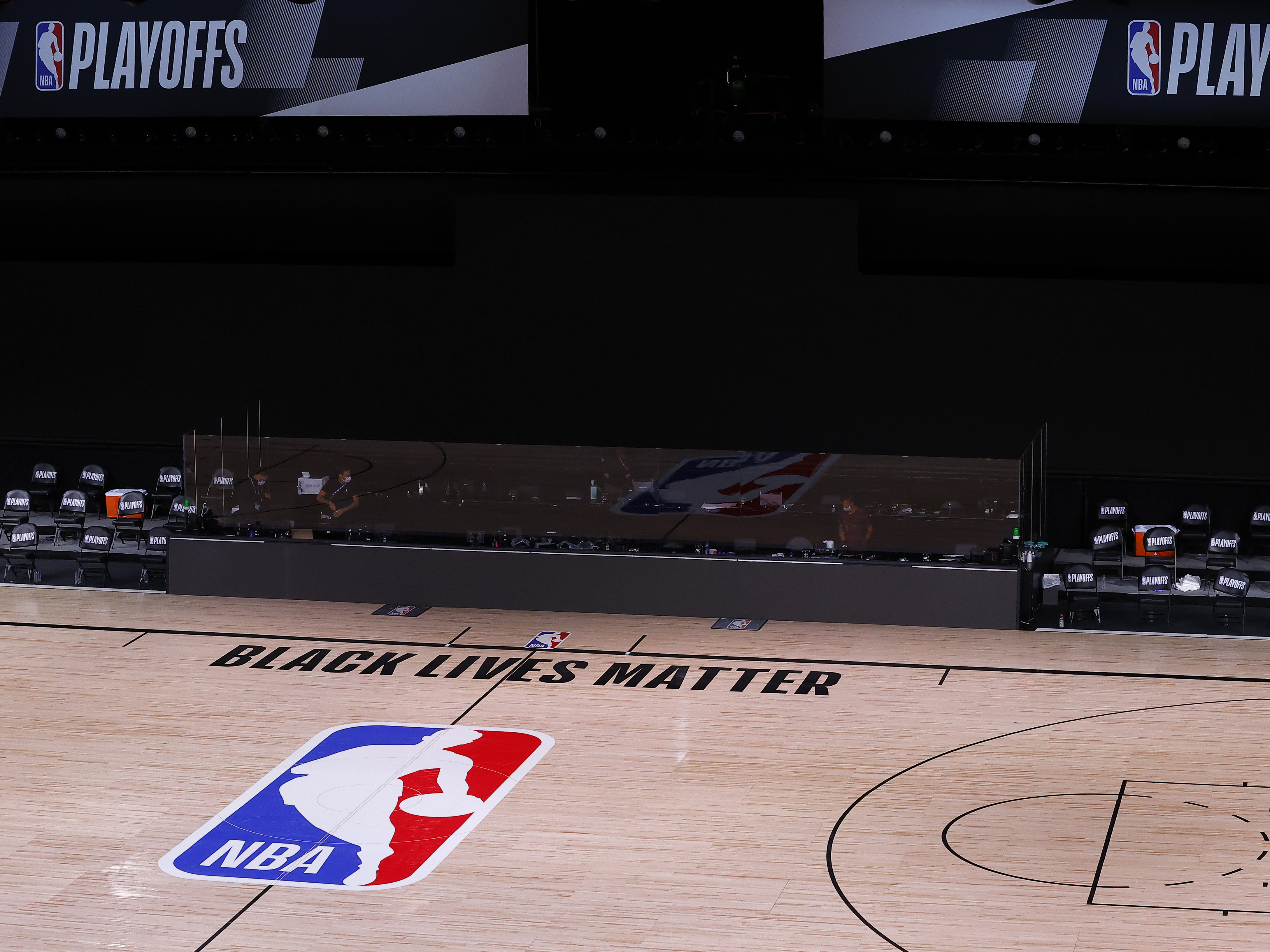 caption: An empty court and bench are shown with no signage following the scheduled start time of Wednesday's NBA playoff series. NBA players made their strongest statement yet against racial injustice Wednesday when the Milwaukee Bucks didn't take the floor for their game against the Orlando Magic.