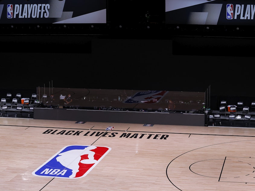 caption: An empty court and bench are shown with no signage following the scheduled start time of Wednesday's NBA playoff series. NBA players made their strongest statement yet against racial injustice Wednesday when the Milwaukee Bucks didn't take the floor for their game against the Orlando Magic.