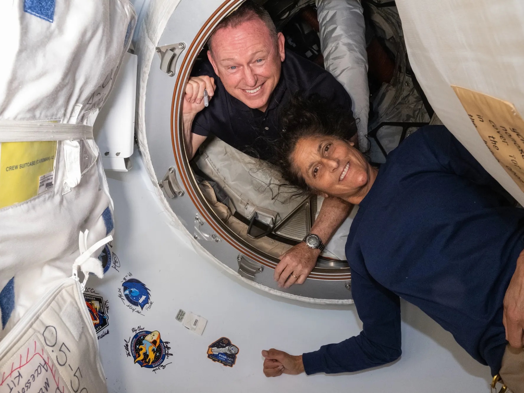 caption: Butch Wilmore and Suni Williams inside the vestibule between the forward port on the International Space Station’s Harmony module and the Starliner spacecraft
