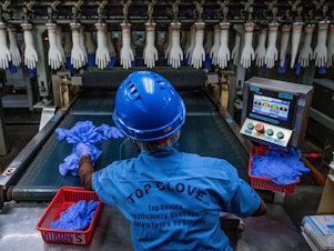 caption: A worker inspects disposable gloves at a factory in Malaysia, a country that has been the top supplier of medical gloves to the U. S. and which is facing increasing competition from China.