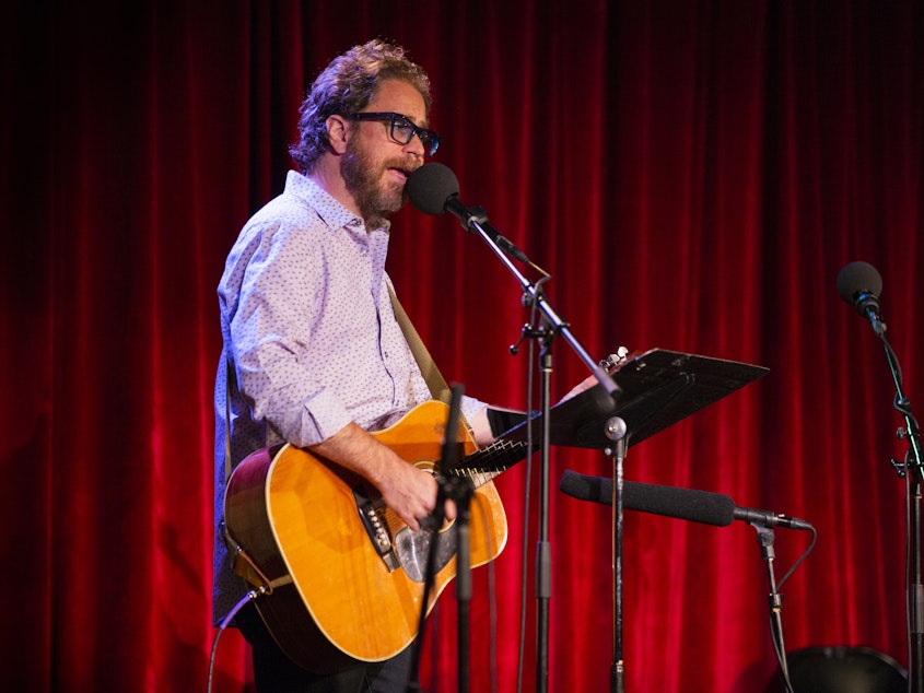 caption: <em>Ask Me Another</em>'s house musician Jonathan Coulton leads a music parody game at the Bell House in Brooklyn, New York.